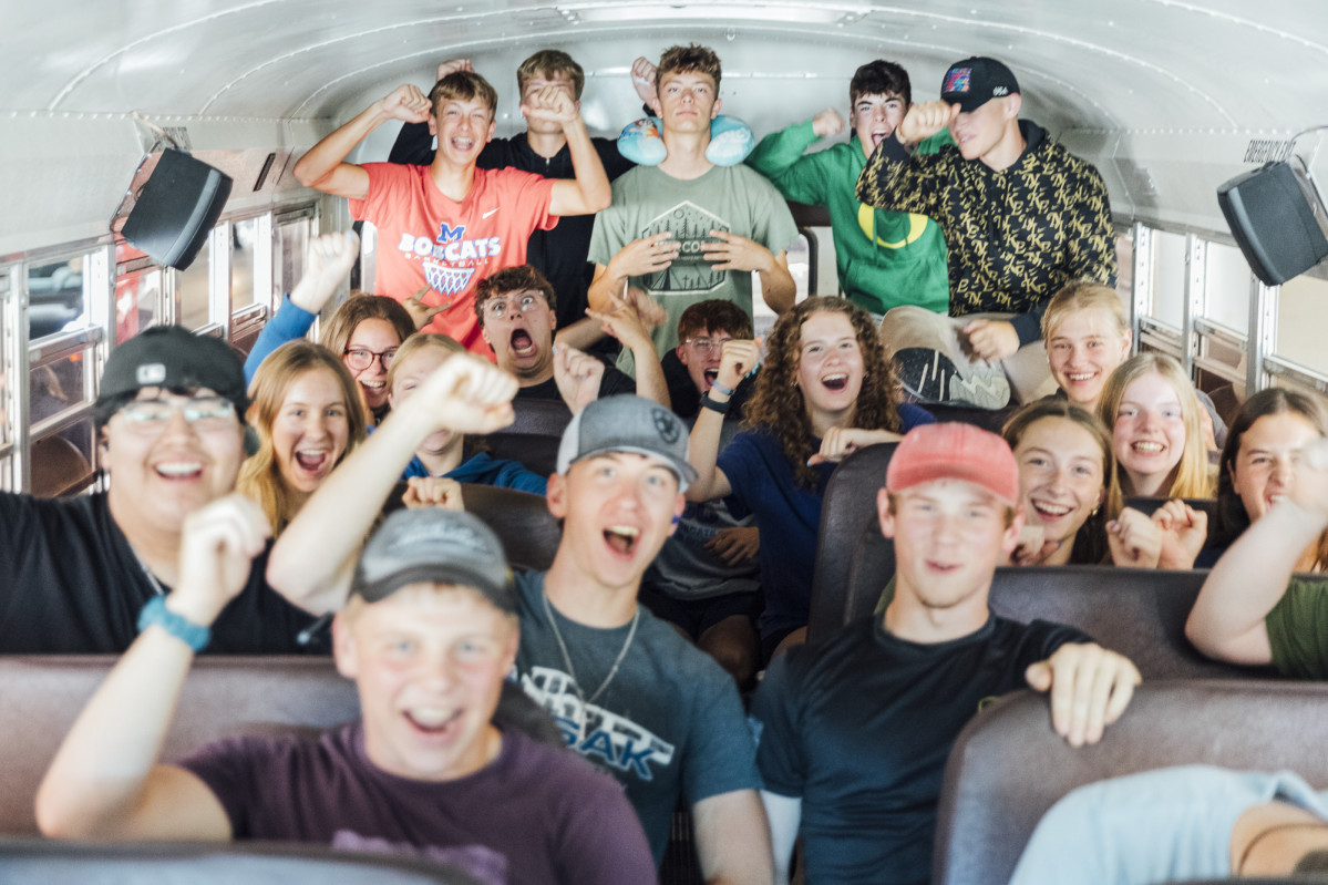 A group of cheering students on a bus